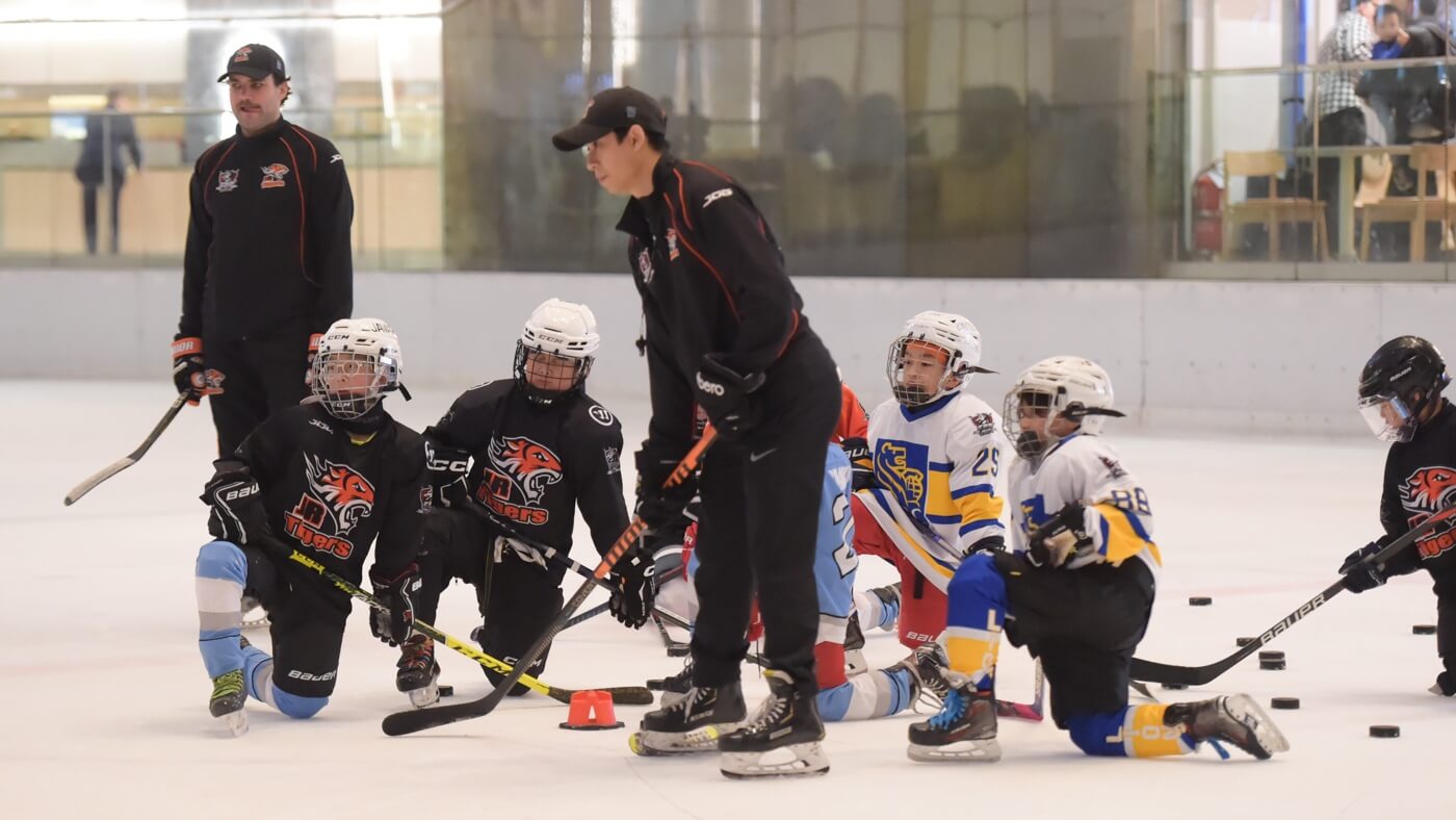 A coach and hockey players at the camp